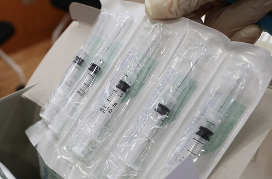 코로나19 백신 접종실에서 의료진이 아스트라제네카(AZ)의 백신 주사액을 담을 특수주사기를 손에 들고 있다. 〈사진-연합뉴스〉