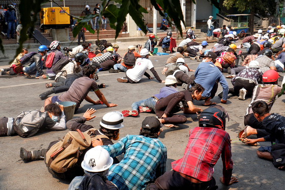 경찰발포에 몸을 숙인 미얀마 시위대의 모습. 〈사진=로이터〉 
