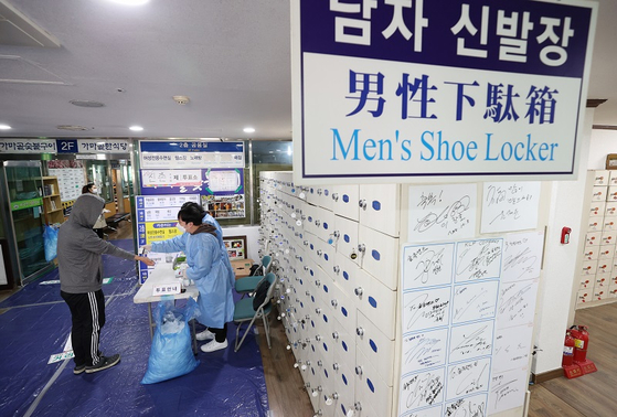 서울 서대문구 한 찜질방에 마련된 투표소에서 유권자가 입구에서 열 체크를 하고 있다.  〈사진-연합뉴스〉
