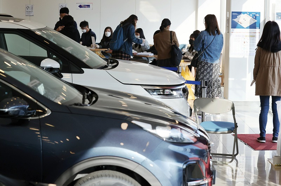 서울 광진구의 한 자동차 대리점에 마련된 투표소에서 유권자들이 투표를 하기 위해 본인 확인 뒤 투표 용지를 받고 있다. 〈사진-연합뉴스〉