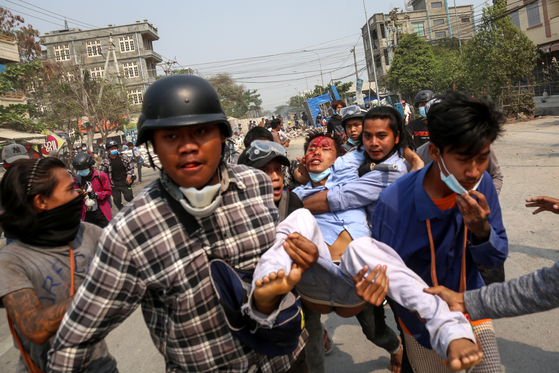 지난달 22일 미얀마 만달레이에서 열린 민주화 운동에서 군부의 폭력에 부상당한 시민들이 옮겨지고 있다. 〈사진=EPA 연합뉴스〉