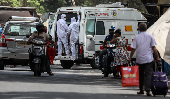 지난 21일 의료 관계자들이 인도 뭄바이 한 코로나19 센터에서 코로나19 의심 환자를 이송하고 있다. 〈사진=EPA 연합뉴스〉