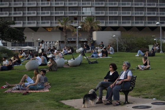 현지 시간 18일 이스라엘 텔아비브에서 마스크를 벗은 사람들이 석양을 보고 있다. 〈사진=AP 연합뉴스〉