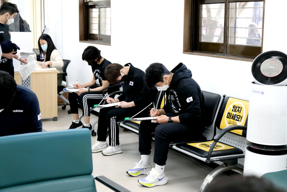 도쿄 올림픽에 출전하는 대표팀 선수들이 코로나19 백신 접종을 앞두고 문진표를 작성하고 있다. 〈사진=대한체육회〉