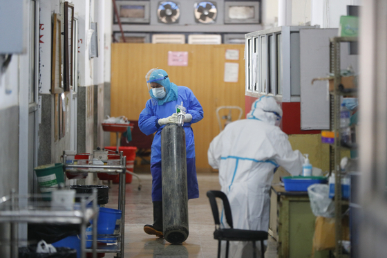 현지 시간 28일 네팔 카트만두 한 병원에서 의료진이 산소탱크를 끌고 있다. 〈사진=AP 연합뉴스〉