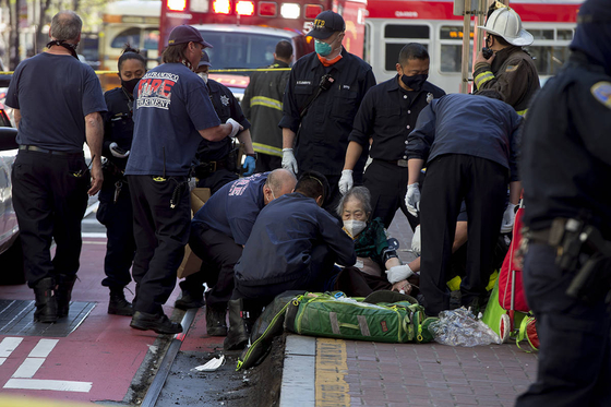 아시아계 노인 두 명이 괴한의 칼에 맞은 직후 미국 샌프란시스코 시내 마켓 스트리트 부근의 버스 정류장 앞에서 응급 처치를 받고 있다. 〈사진=S.F. Examiner〉