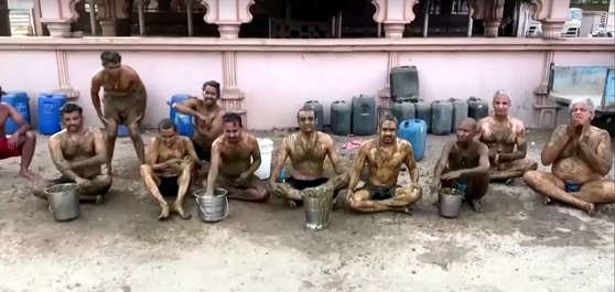 현지시간 9일 인도 구자라트에서 힌두교도들이 모여 온몸에 소똥을 바르고 있다. 〈사진=로이터 캡처〉