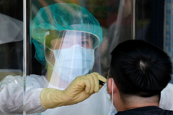 지난 21일 대만 신베이시 한 코로나19 검사소에서 의료진이 검체를 채취하고 있다. 〈사진=AFP 연합뉴스〉
