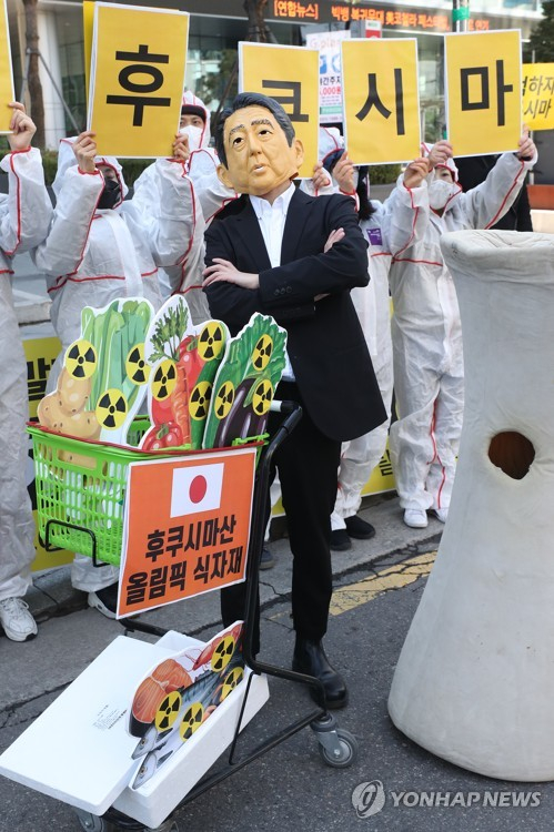 지난해 3월 한 시민단체 회원이 아베 전 총리의 가면을 쓰고 후쿠시마산 식자재 사용 반대 시위를 하고 있다.   