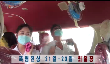 차량 안에 설치된 선풍기 바람을 쐬는 북한 주민들. 〈사진=연합뉴스〉  