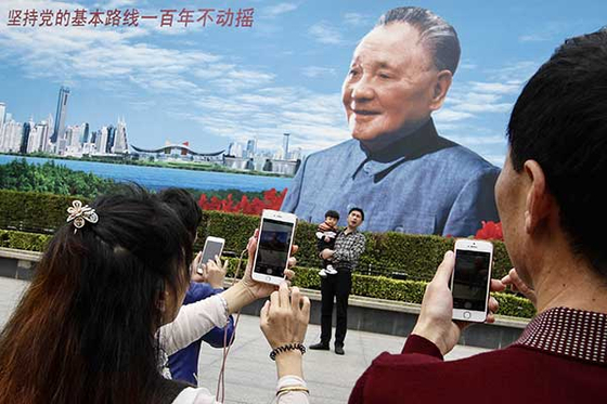 덩샤오핑 대형 사진 앞에서 기념 사진을 찍고 있는 중국 인민들.〈사진= 바이두 캡처〉
