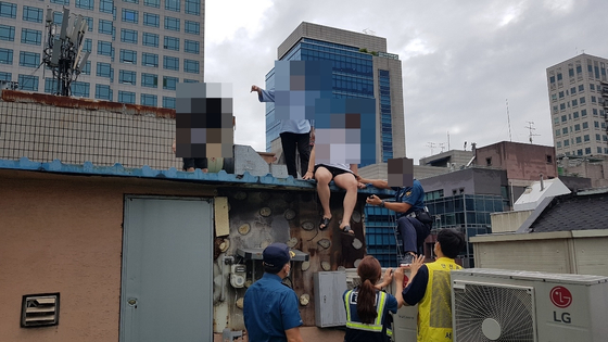 결국 경찰의 도움으로 옥상에서 내려오는 유흥주점 손님들. [서초경찰서 제공]
