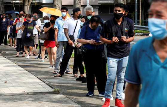 지난달 21일 싱가포르에서 코로나19 검사를 받기 위해 사람들이 간이검사소 밖에서 줄을 서고 있다. 〈사진=로이터 연합뉴스〉