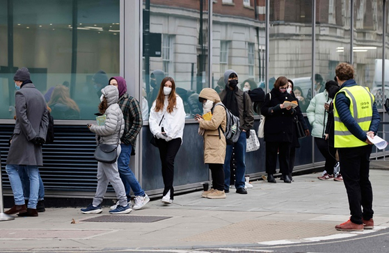 런던에서 마스크를 쓴 시민들이 코로나19 백신을 맞기 위해 줄 서 있는 모습. 〈사진-AFP연합뉴스〉