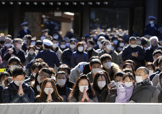 2022년 새해 첫날, 일본 도쿄 메이지 신궁에 모인 인파. 경찰 통제 하에 기도를 하고 있는 모습 〈사진=연합뉴스/EPA〉
