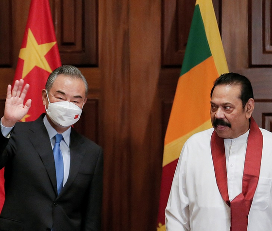 9일(현지 시각) 스리랑카 수도 콜롬보에서 마힌다 라자팍사(오른쪽) 스리랑카 총리와 왕이(왼쪽) 중국 외교부장이 만났다. [사진=AP, 연합뉴스]
