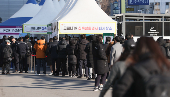 코로나19 사태 후 처음으로 하루 10만 명이 넘는 신규확진자가 발생한 18일 오전 서울 중구 서울역 임시 선별검사소에서 시민들이 길게 줄지어 검사를 기다리고 있다. 〈사진=연합뉴스〉