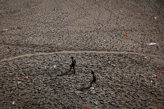 지난달 30일 인도 뉴델리에서 말라붙은 야무나의 강바닥을 걷고 있다. 〈사진=로이터 연합뉴스〉