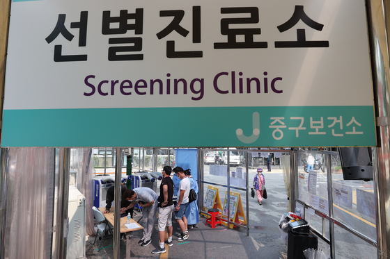 지난 5일 오후 서울 중구보건소에 마련된 선별진료소를 찾은 시민들이 의료진에게 안내를 받고 있다. 〈사진-연합뉴스〉