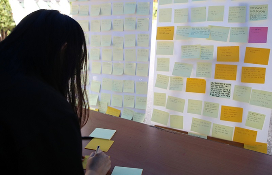 인하대학교 캠퍼스에 마련된 피해자를 위한 추모 공간에서 한 학생이 추모 메시지를 쓰고 있다. 〈사진-연합뉴스〉