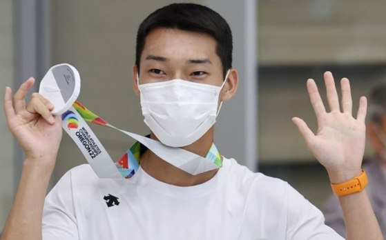 한국 육상 첫 '세계선수권대회 은메달'을 획득한 남자 높이뛰기 우상혁이 21일 오후 인천국제공항 제2여객터미널을 통해 귀국하며 메달을 목에 걸고 인사하고 있다. 〈사진=연합뉴스〉