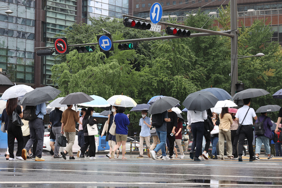 전국 곳곳 비 소식이 예보된 지난 21일 오전 서울 종로구 광화문네거리에서 시민들이 우산을 쓴 채 이동하고 있다. 〈사진=연합뉴스〉