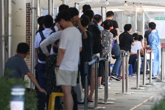 25일 오전 서울 마포구보건소에 마련된 선별진료소에서 시민들이 검사를 기다리며 줄을 서고 있다. 〈사진=연합뉴스〉
