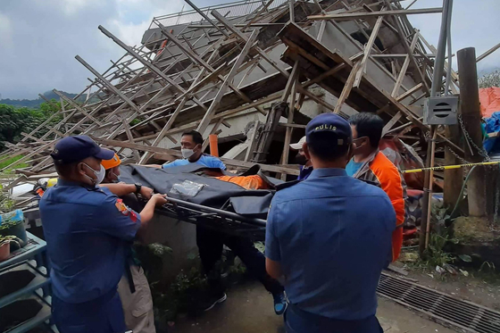 This handout photo taken from the Facebook page of La Trinidad Municipal Police Station shows a rescue team moving the body of a construction worker at the site of a collapsed building in La Trinidad, in the province of Benguet on July 27, 2022, after a 7.0-magnitude earthquake hit the northern Philippines. - A 25-year-old construction worker in La Trinidad, the capital of the landlocked province Benguet, died when the three-storey building he was working on collapsed, police said. (Photo by Handout / La Trinidad Municipal Police Station / AFP) / RESTRICTED TO EDITORIAL USE - MANDATORY CREDIT &#34;AFP PHOTO / La Trinidad Municipal Police Station &#34; - NO MARKETING - NO ADVERTISING CAMPAIGNS - DISTRIBUTED AS A SERVICE TO CLIENTS    〈저작권자(c) 연합뉴스, 무단 전재-재배포 금지〉