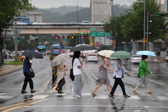 지난달 31일 오후 서울 서초구 고속버스터미널 인근에서 우산을 쓴 시민들이 발걸음을 재촉하고 있다. 〈사진=연합뉴스〉