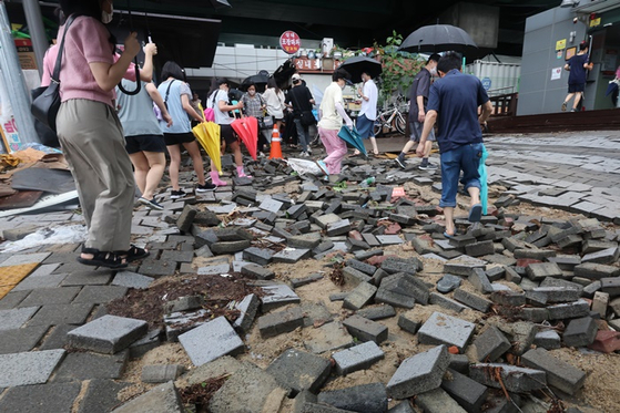 오늘(9일) 오전 서울 동작구 신대방역 앞 보도블록이 간밤 폭우로 파손된 모습. 〈사진-연합뉴스〉 