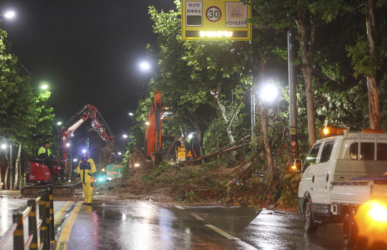 오늘(9일) 오전 서울 서초구 한 도로에 산사태가 발생해 일부 차선 통제와 복구 작업이 이뤄지고 있다. 〈사진=연합뉴스〉