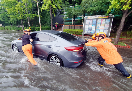 폭우가 내린 지난 8일 인천시 미추홀구 용현동 한 도로에서 소방대원들이 침수된 차량을 안전한 곳으로 옮기고 있다. 〈사진=인천소방본부 제공〉