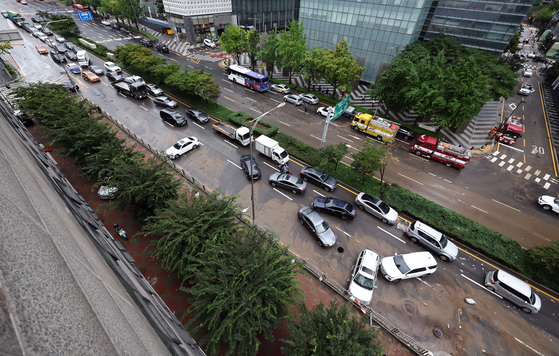 지난 9일 오전 서울 서초구 진흥아파트 앞 서초대로 일대에서 출근길 차량들이 전날 내린 폭우에 침수됐던 차량을 피해가고 있다. 〈사진=연합뉴스〉