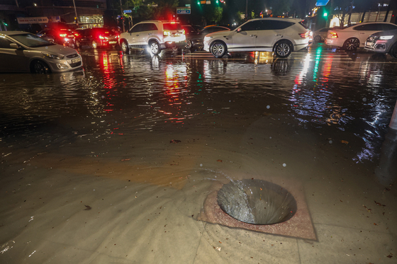 지난 9일 새벽 폭우로 다수의 차량이 침수된 서울 강남구 대치사거리의 배수구가 뚜껑이 없어진 채 소용돌이치고 있다. 〈사진=연합뉴스〉