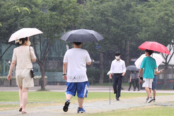 전국 대부분 지역에 소나기가 예보된 지난 7월 22일 오후 서울광장에서 시민들이 우산을 쓴 모습. 〈사진-연합뉴스〉  