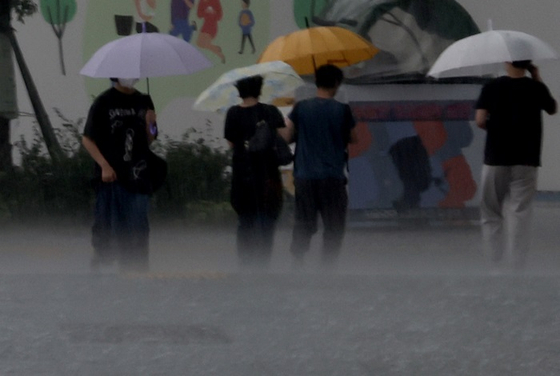 서울 지역에 오후부터 비가 내린 19일 서울 세종대로 광화문광장에서 우산을 쓴 시민들이 횡단보도를 건너고 있다. 〈사진-연합뉴스〉