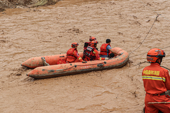 지난 7월 16일 중국 북서부 간쑤성 칭양에서 홍수가 나 구조대원들이 보트를 타고 구조에 나선 모습. 〈사진=AFP 연합뉴스〉